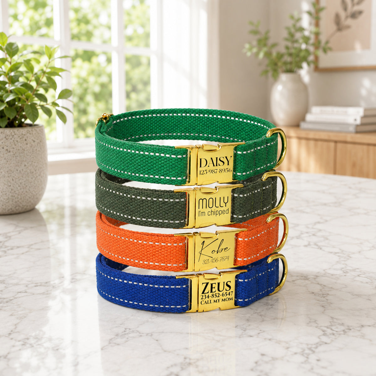 Stack of colorful dog collars with gold buckles on a marble surface.
