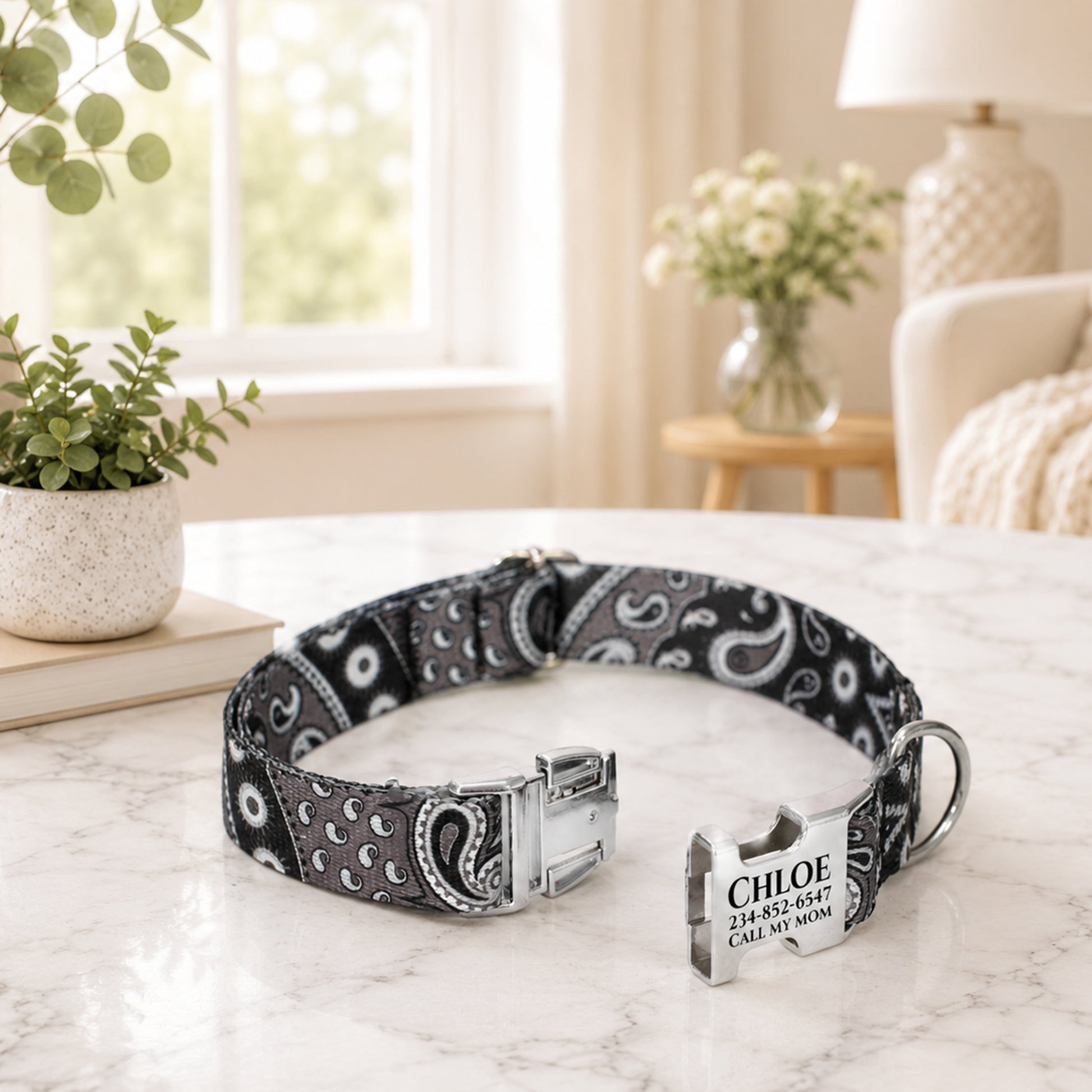 Black and white patterned dog collar with a name tag on a marble surface.
