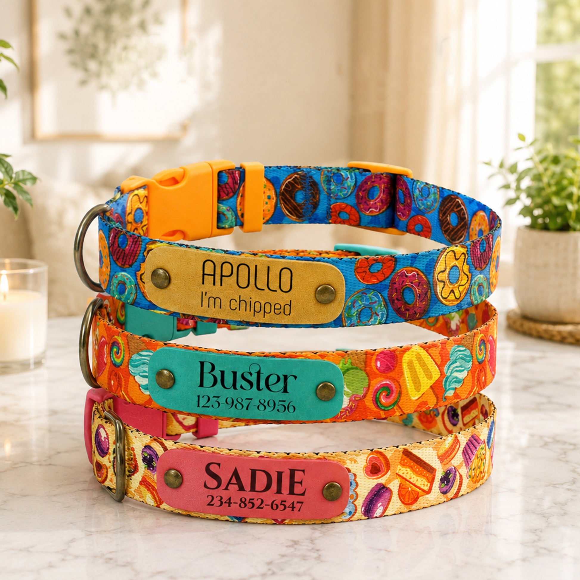 Colorful dog collars with personalized nameplates on a marble surface.