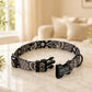 Black and white patterned dog collar with a tag on a marble surface