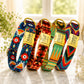Four colorful dog collars with gold buckles on a marble surface.