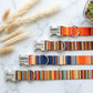 Striped dog collar with engraved nameplate – side view on marble surface