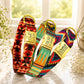 Three colorful dog collars with gold tags on a marble surface.