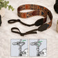 Decorative camera strap with intricate patterns on a light surface.