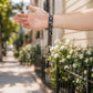 Hand holding a keychain with keys against a blurred outdoor background