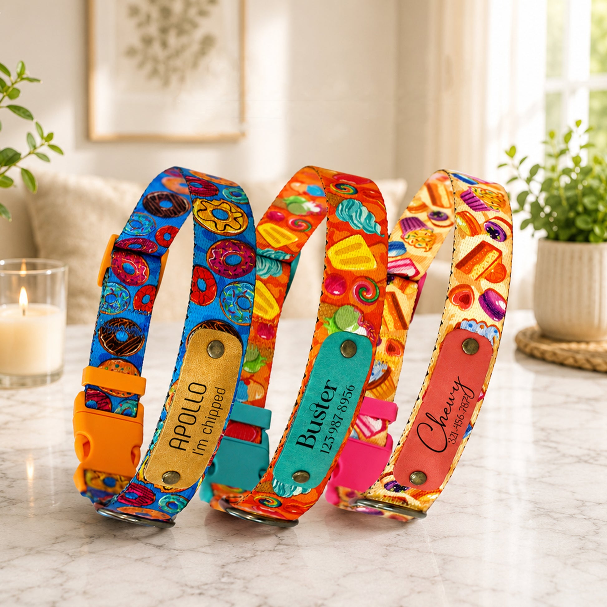 Three colorful dog collars with names on a marble surface.