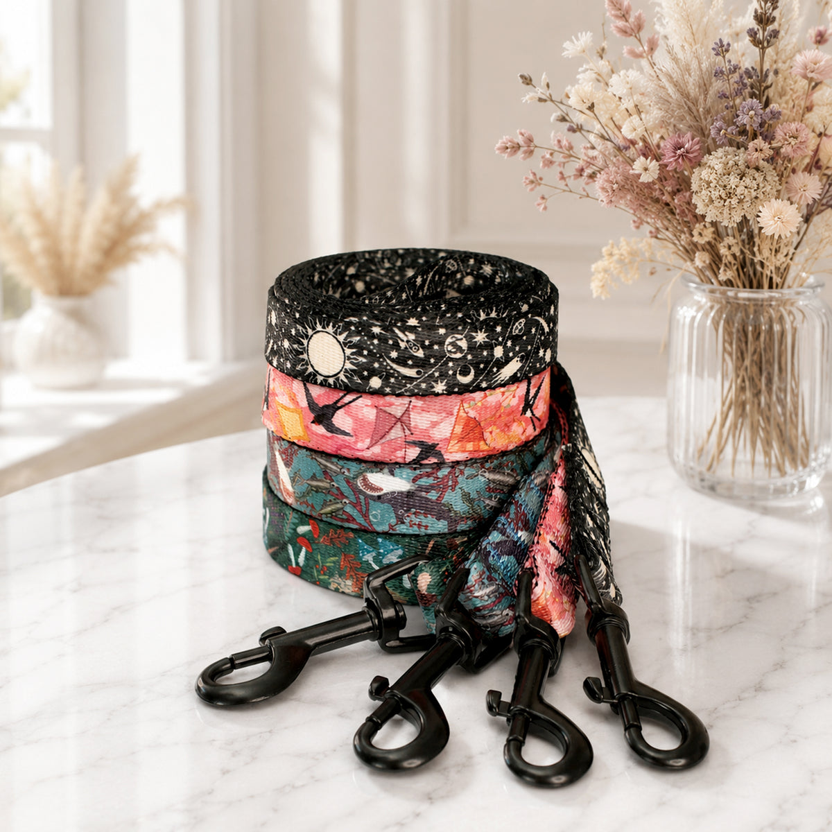 Colorful dog leash and collar set on a marble surface with a vase of flowers in the background.