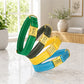 Four colorful dog collars with engraved names on a marble surface.