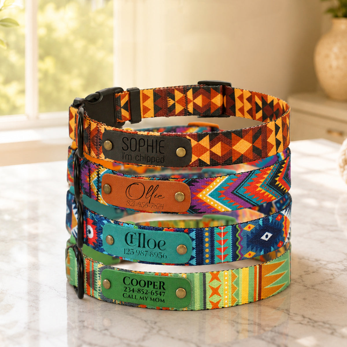 Colorful dog collars with engraved names on a marble surface