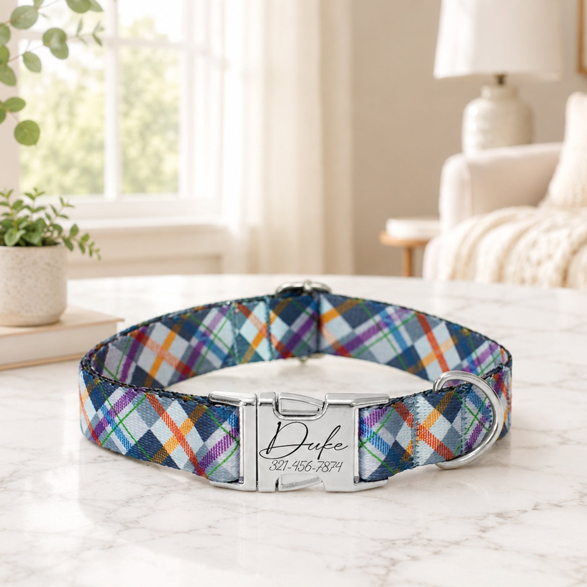 Colorful plaid dog collar with a metal tag on a marble surface.