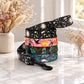 Stack of colorful dog leashes on a marble surface with decorative flowers in the background