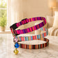 Colorful striped dog leash with a bell on a marble surface