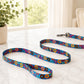 Colorful floral-patterned dog leash on a white surface with a plant in the background