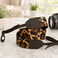 Leopard print camera strap on a marble surface with a blurred indoor background