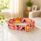 Floral patterned dog collar with gold hardware on a marble surface
