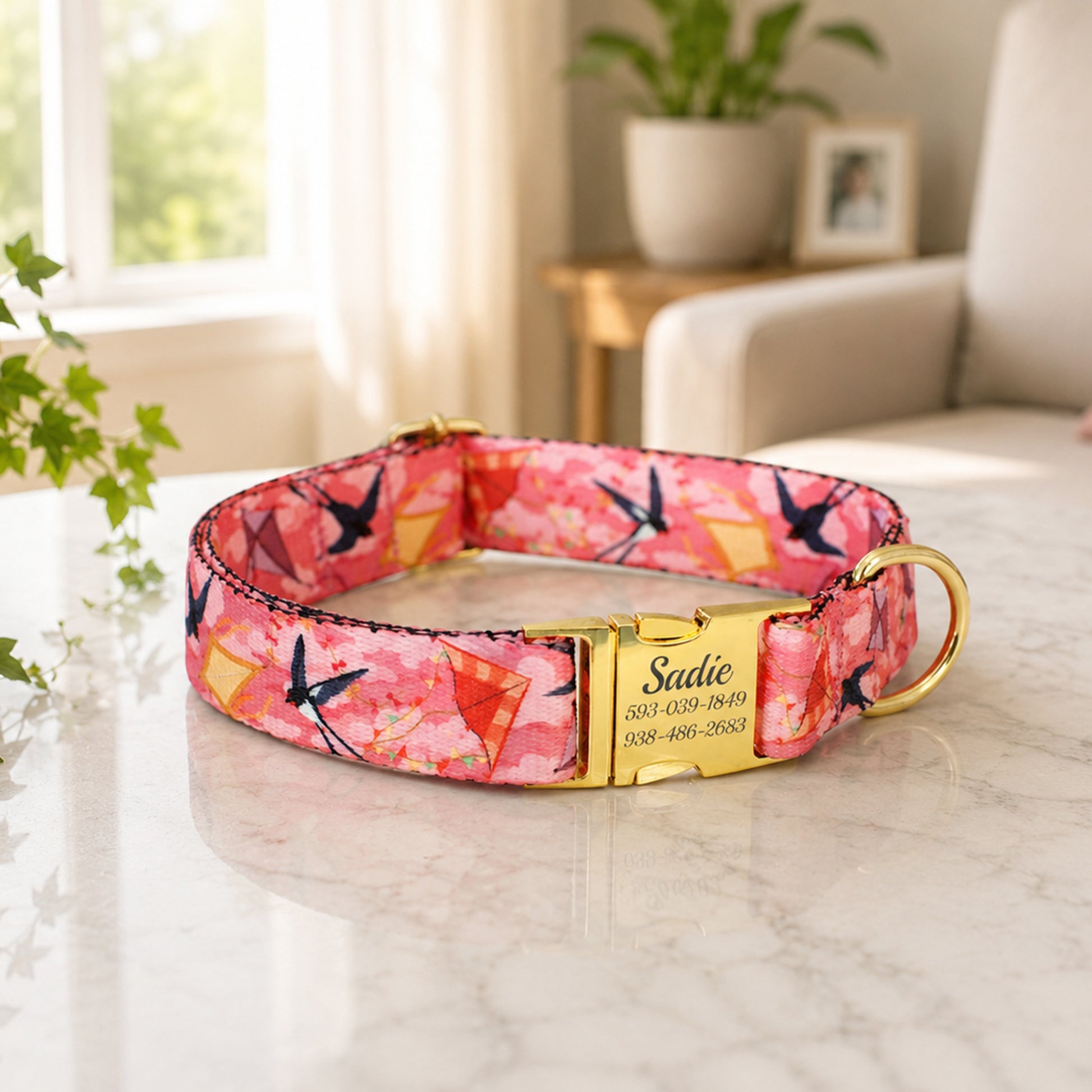 Pink floral dog collar with gold clasp on a marble surface, blurred indoor background