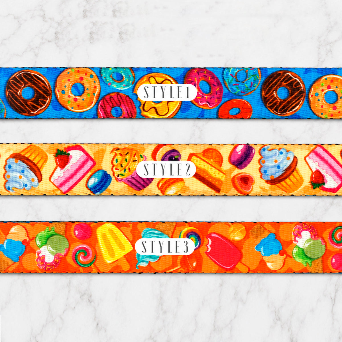 Three colorful wristbands with donut, candy, and fruit designs on a white marble background.