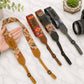 Collection of colorful camera straps with unique patterns and text on a light surface.