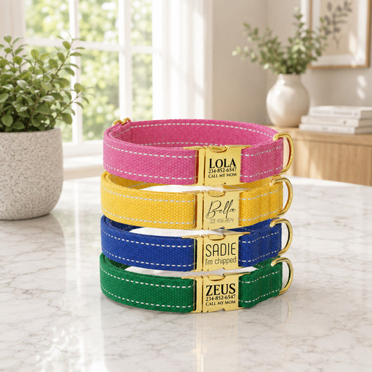 Stack of colorful dog collars with engraved names on a marble surface.
