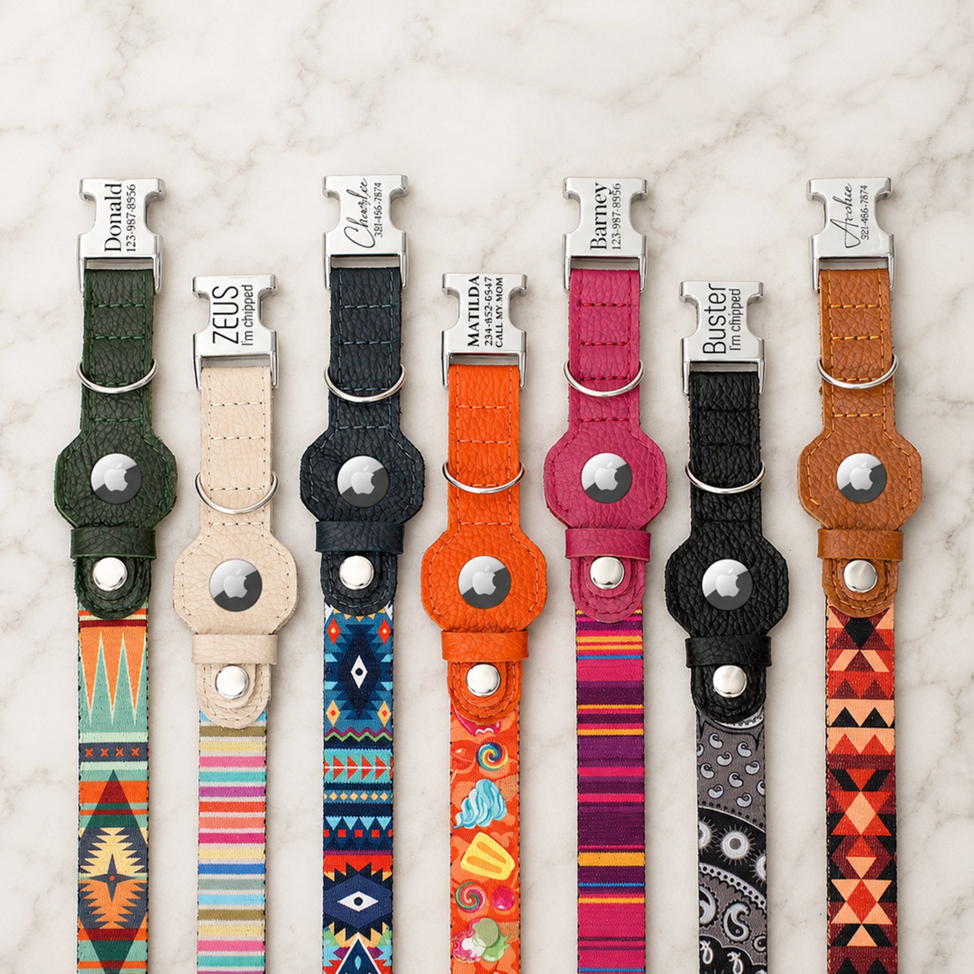 Collection of colorful dog collars with brand names on a marble surface