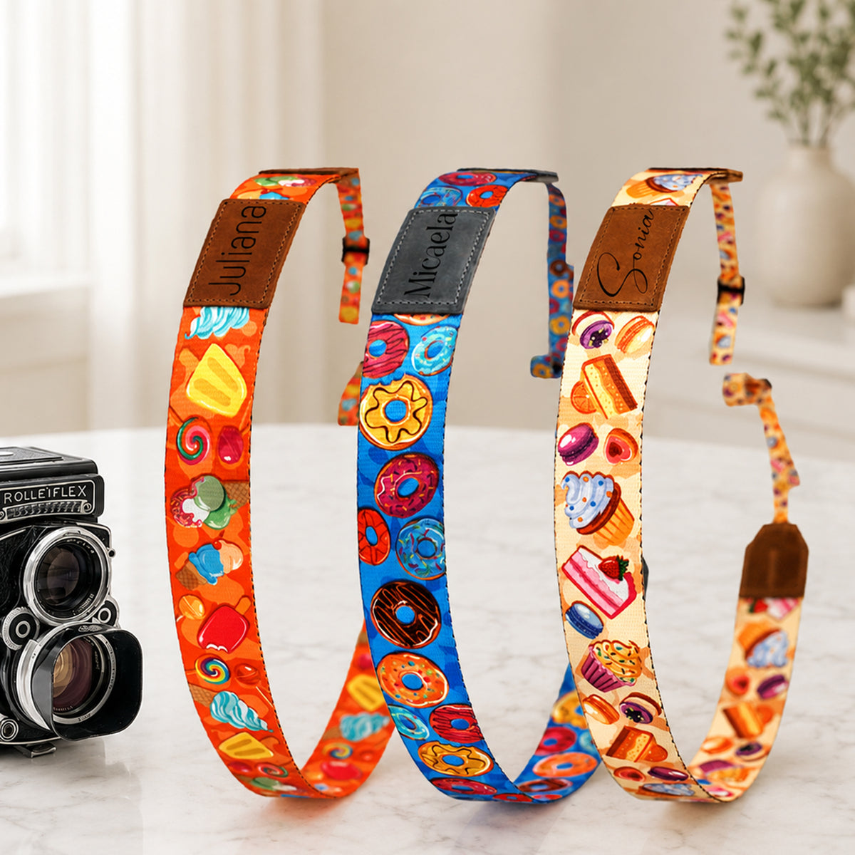 Three colorful camera straps with unique patterns on a white surface.