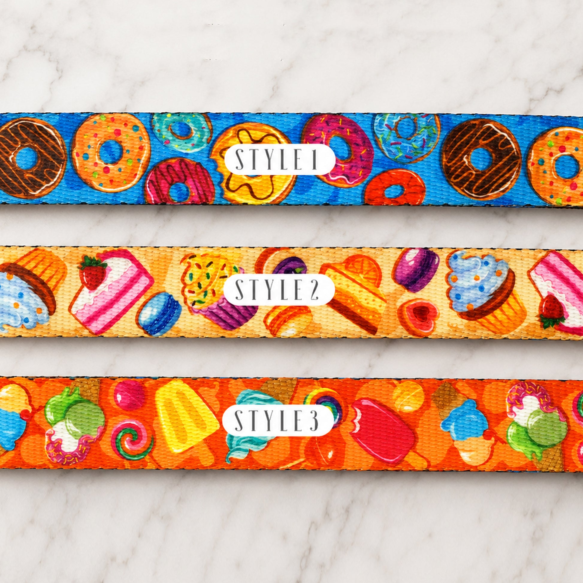 Three colorful dog collars with different patterns on a marble surface