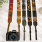 Collection of patterned camera straps with a Canon camera on a light background
