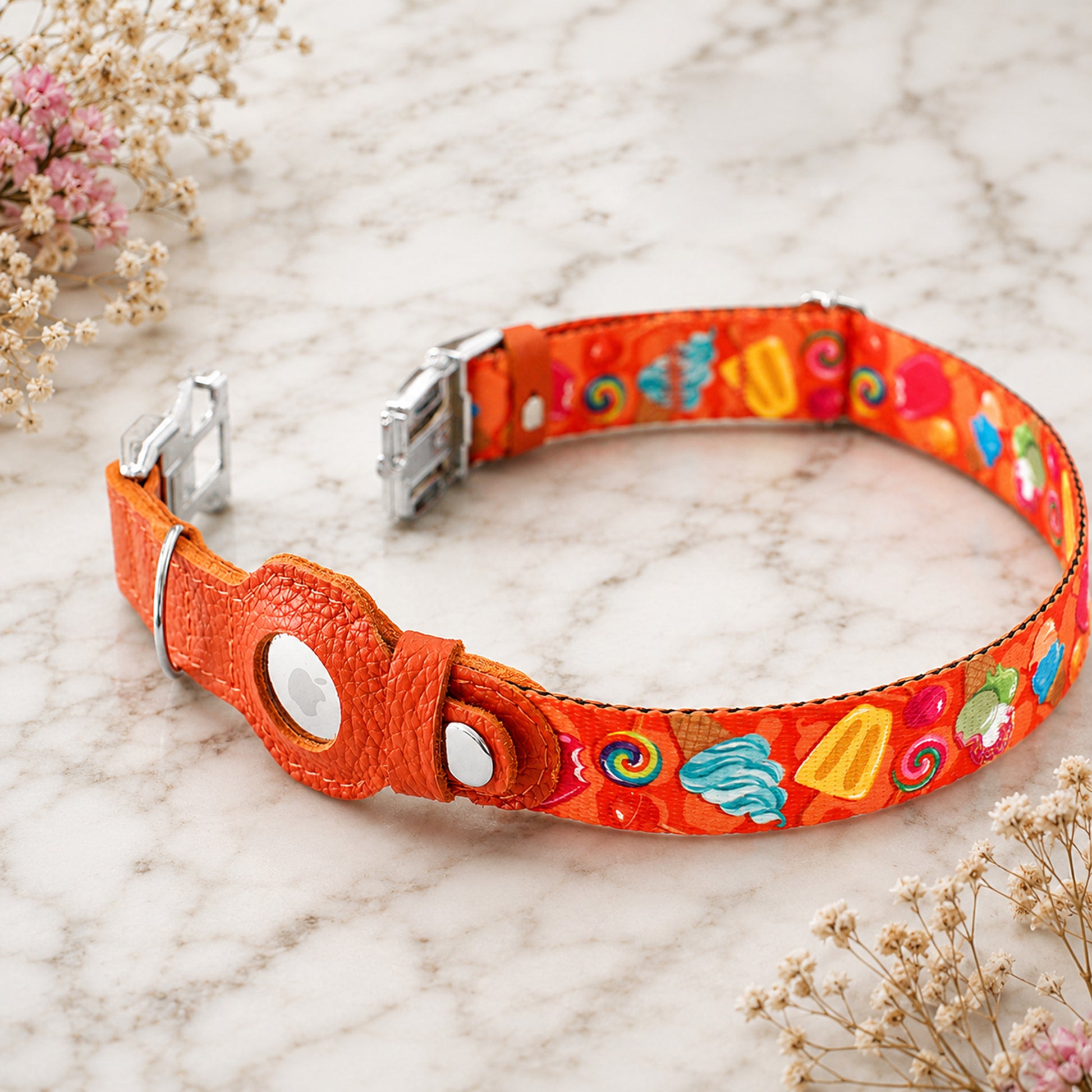 Colorful dog collar with candy-themed design on a marble surface.
