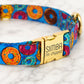 Colorful dog collar with gold buckle and 'Simba I'm chipped' tag on a marble background
