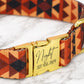 Dog collar with geometric pattern and gold buckle on a marble surface
