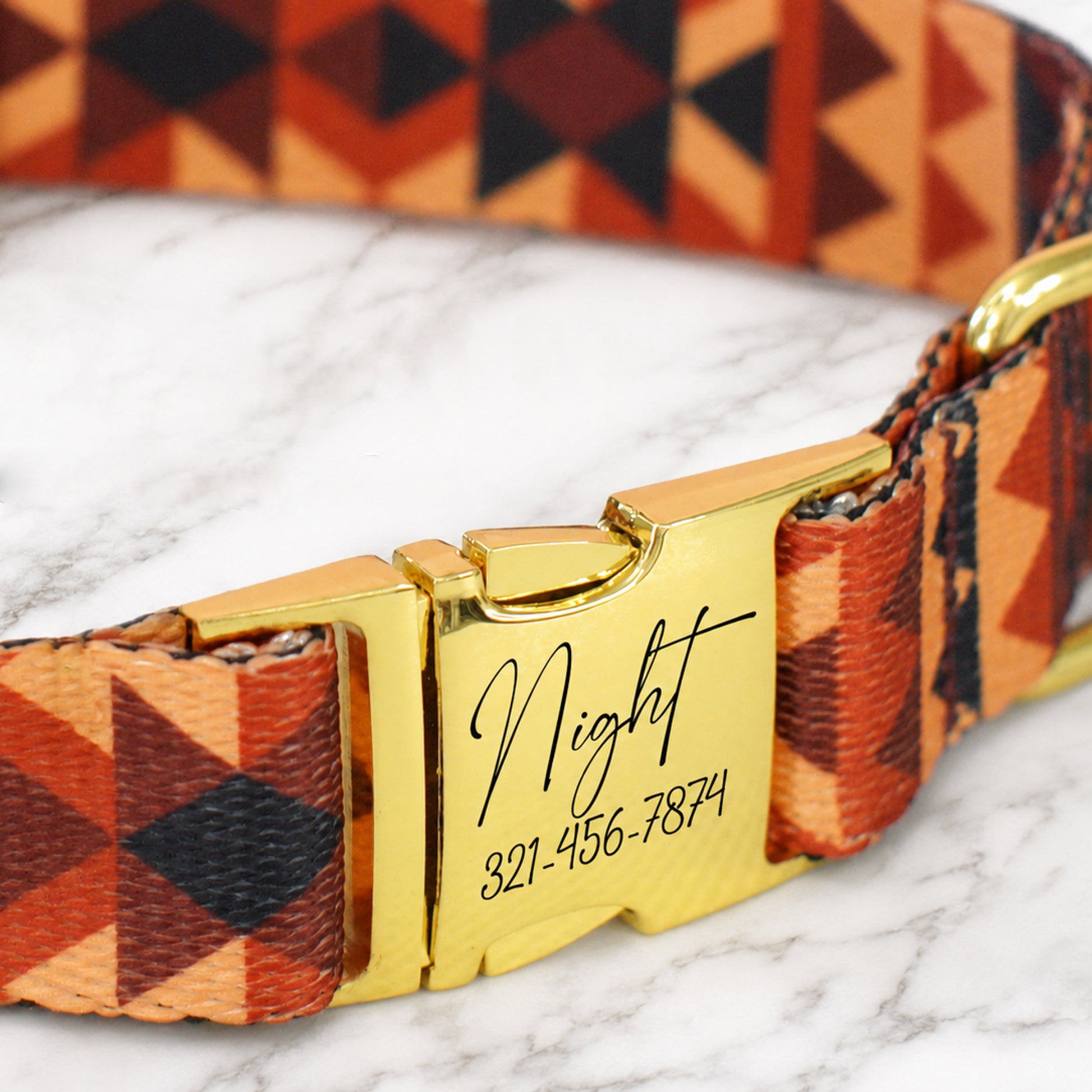 Dog collar with geometric pattern and gold buckle on a marble surface