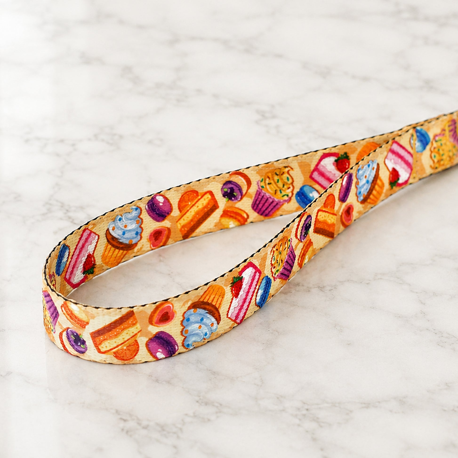 Colorful fabric belt with dessert pattern on a marble surface