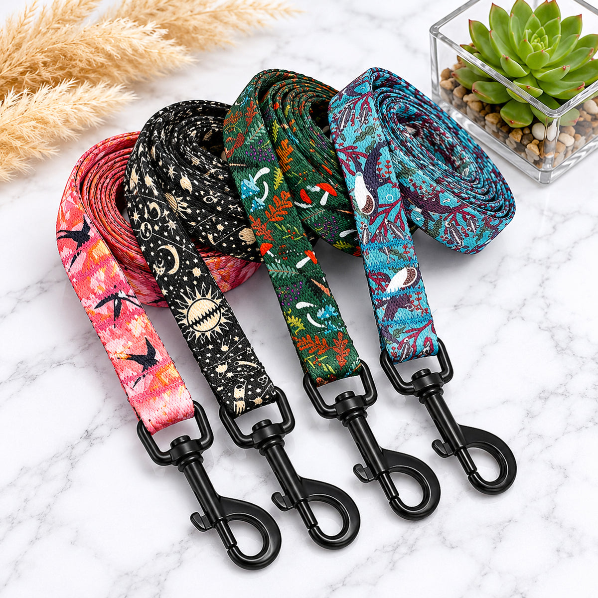 Four colorful dog leashes with patterned designs on a marble surface.