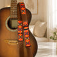 Acoustic guitar with a colorful strap in a home setting