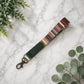 Colorful striped keychain on a marble surface with green leaves