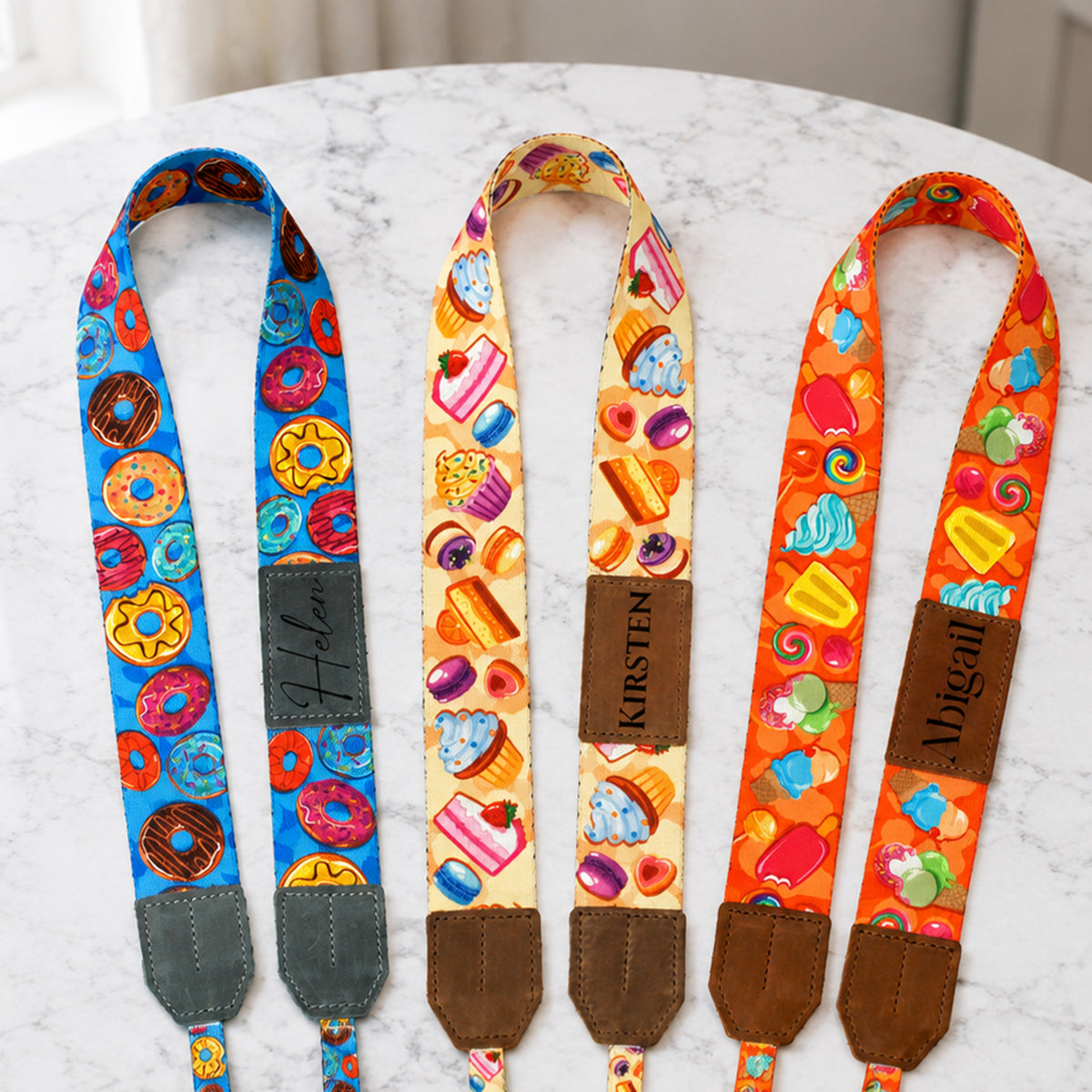 Three colorful fabric straps with different patterns on a marble surface.