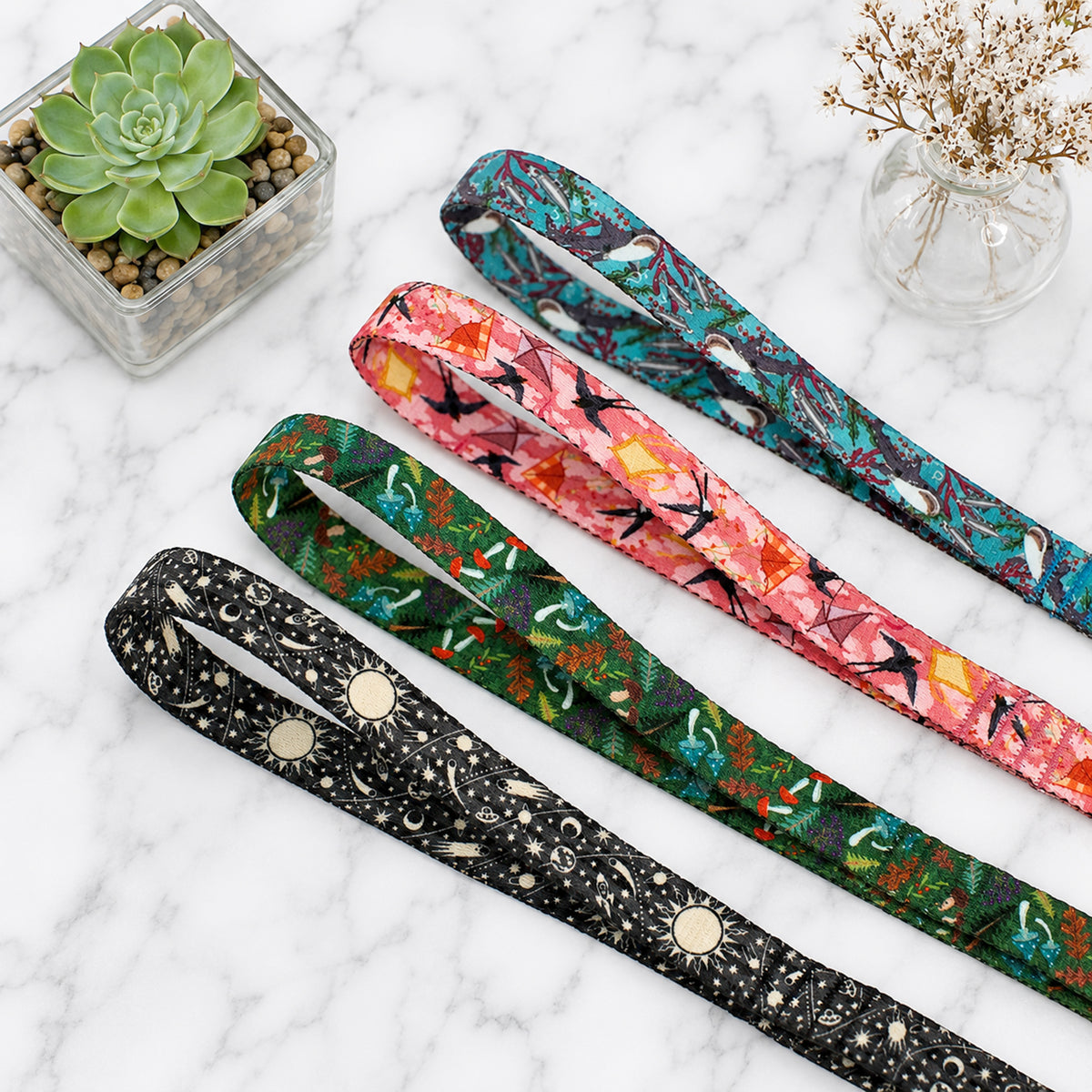 Three patterned belts on a marble surface with decorative elements.