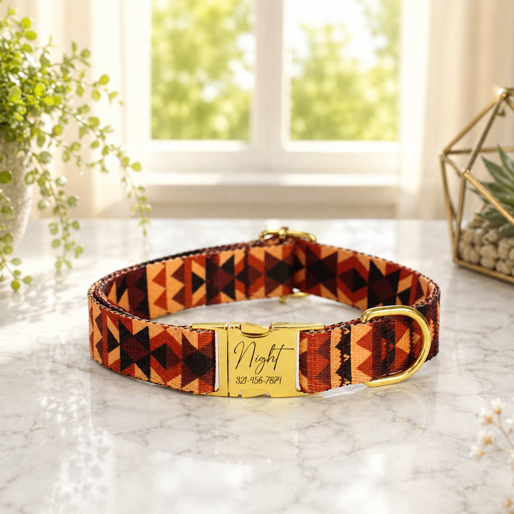 Dog collar with geometric pattern and gold buckle on a marble surface