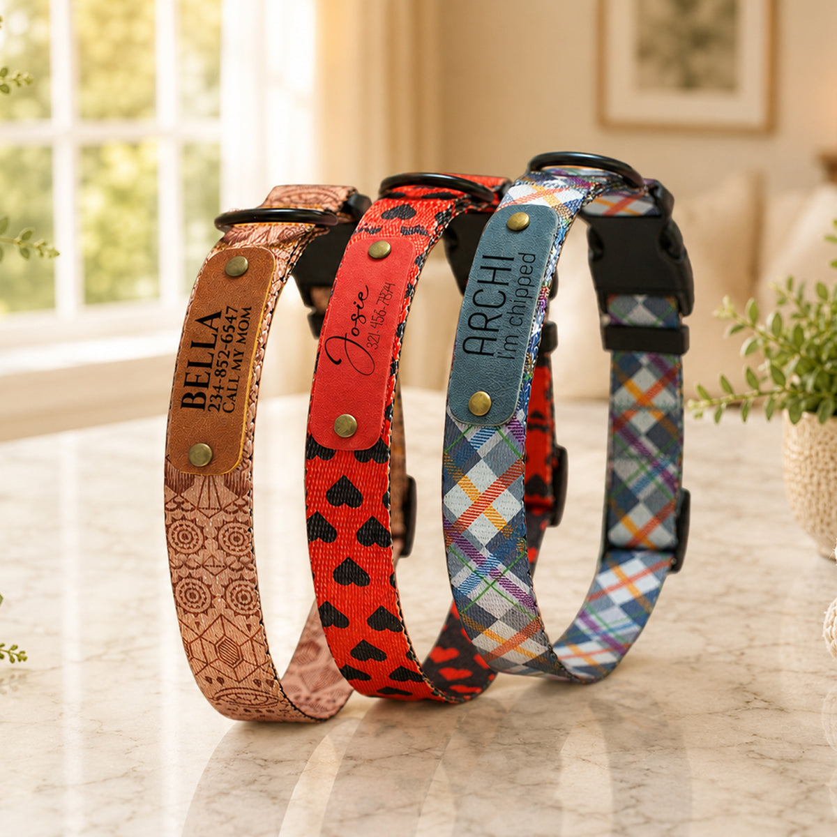 Four dog collars with different designs and text on a marble surface.