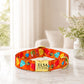 Colorful dog collar with a gold tag on a light surface with a blurred background