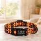 Dog collar with geometric pattern and engraved name and contact information on a marble surface.