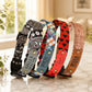 Five patterned dog collars with engraved names on a marble surface.
