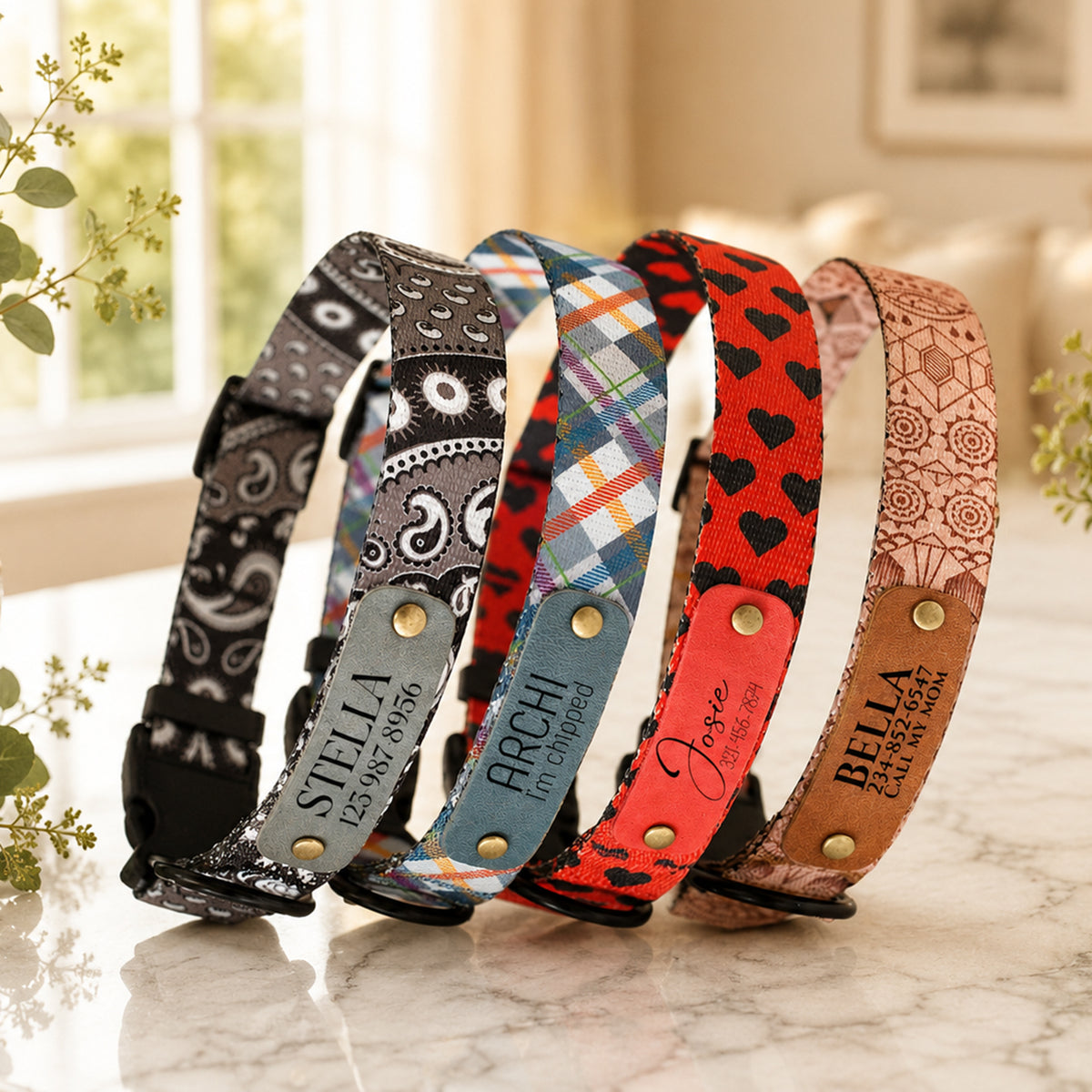 Five patterned dog collars with engraved names on a marble surface.