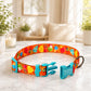 Colorful dog collar with a name tag on a marble surface