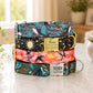 Stack of colorful dog collars with engraved names on a light surface.