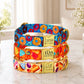 Colorful dog collars with personalized names on a marble surface.
