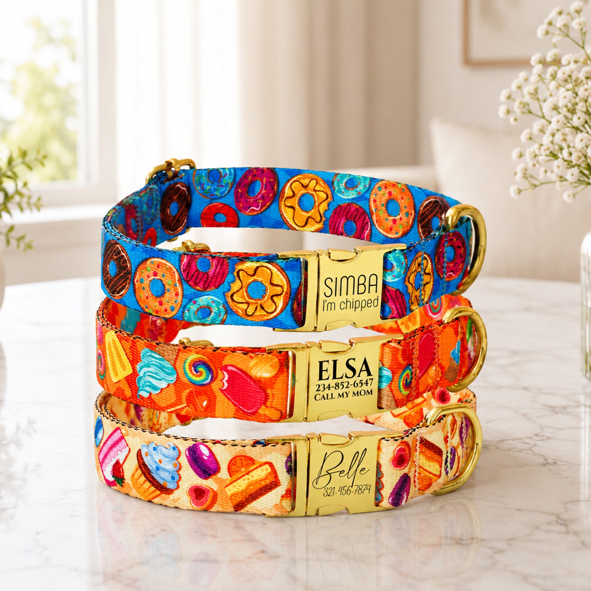 Colorful dog collars with personalized names on a marble surface.