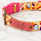 Colorful dog collar with a pink name tag on a marble surface