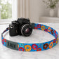 Camera with a colorful donut patterned strap on a marble surface