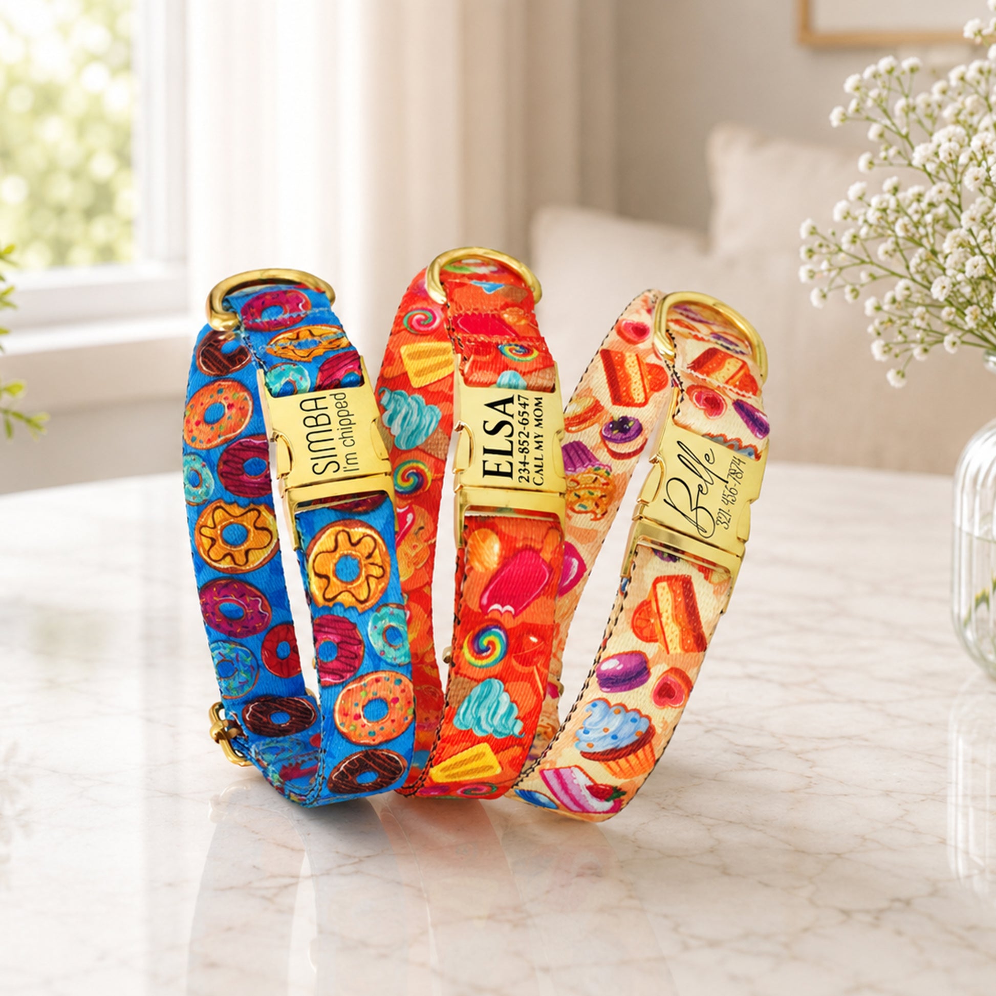 Three colorful dog collars with brand names on a light surface.
